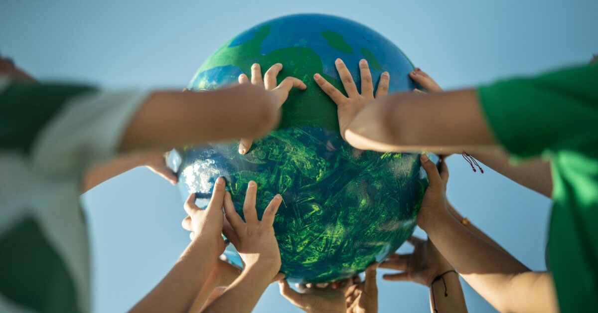 a group of hands holding a globe